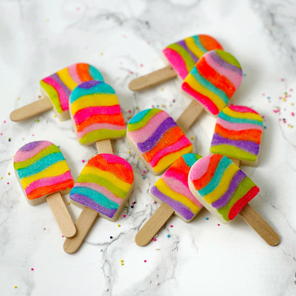 IMG_2965  1688 × 1688px  fantasy rainbow glitter candy marzipan popsicles next to fruit flatlay