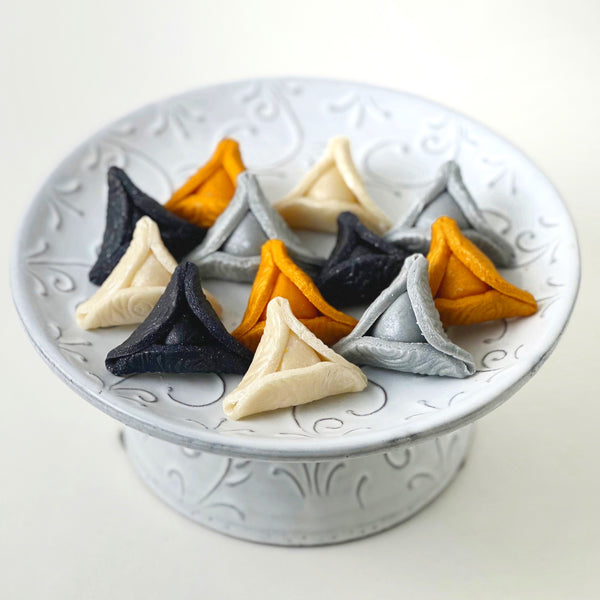 elegant purim gold hamantaschen on a pedestal