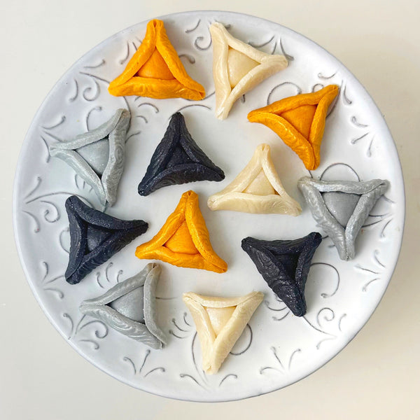 elegant purim gold hamantaschen on a plate