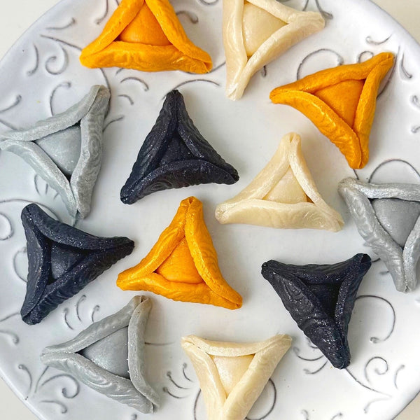 elegant purim gold hamantaschen on a plate closer