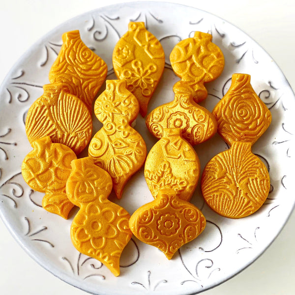luxe gold marzipan christmas ornaments assorted on a plate