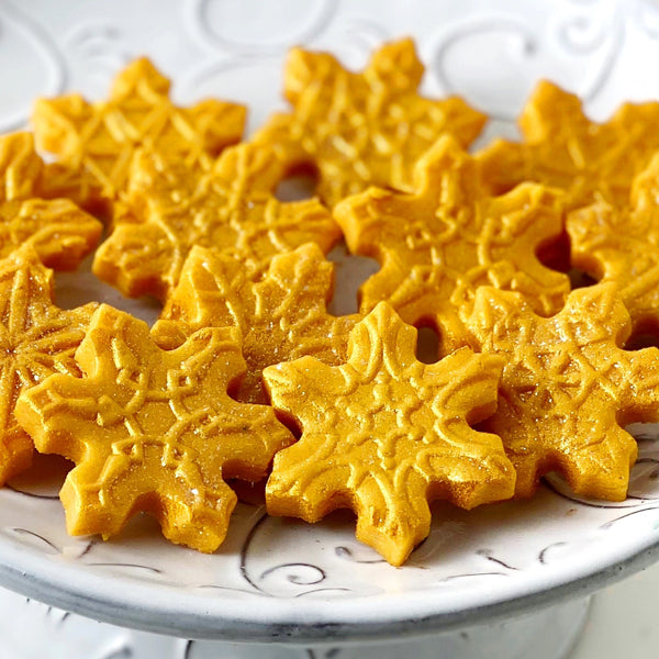 gold snowflake marzipan candy tiles on a plate