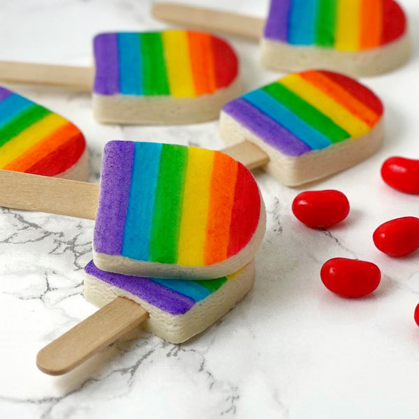 rainbow ice popsicles marzipan candy lollipops with real sticks closeup with jelly beans