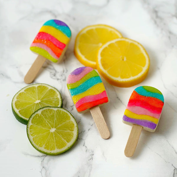 fantasy rainbow glitter candy marzipan popsicles next to fruit