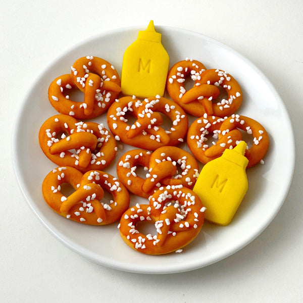 marzipan pretzels and mustard on a plate
