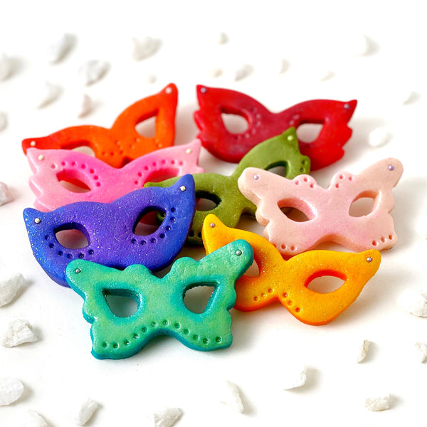 Purim rainbow glitter masks marzipan candy treats in a pile