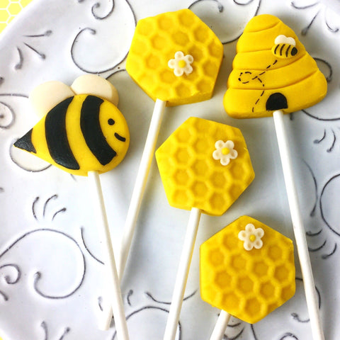 Rosh Hashanah honeybee collection with bees, beehives and honeycomb marzipan candy lollipops on a plate