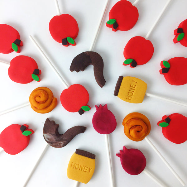 Rosh Hashanah collection candid shot with apples, honey, shofar, challah and pomegranate marzipan candy lollipops