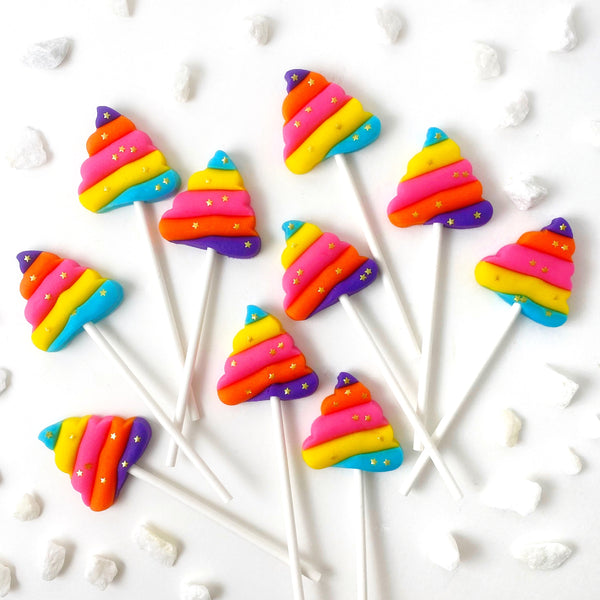rainbow unicorn poop with gold stars marzipan candy lollipops flatlay