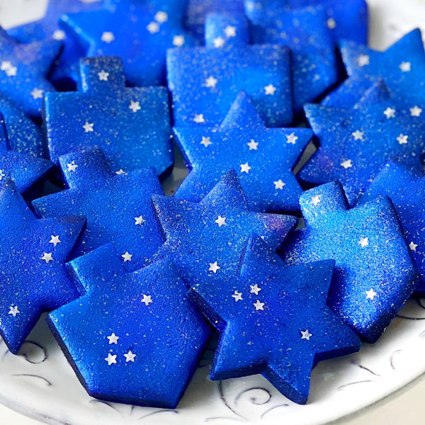 galaxy dreidels star of David hanukkah sparkly tiles closeup on a plate