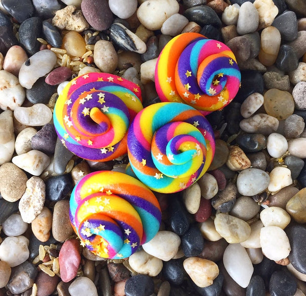 rainbow unicorn poop marzipan candy sculpture treats on a bed of rocks